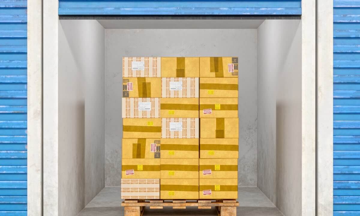 A photo showing a storage unit with a pallet stacked with boxes inside of it.