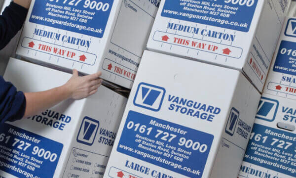 A photo showing a person stacking up Vanguard's cardboard boxes.