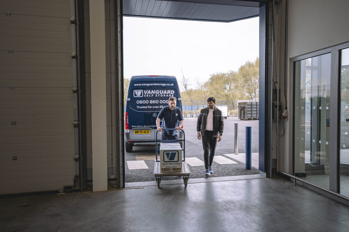 A photo showing a Vanguard employee helping a customer move his boxes into one of the Vanguard Self Storage units.
