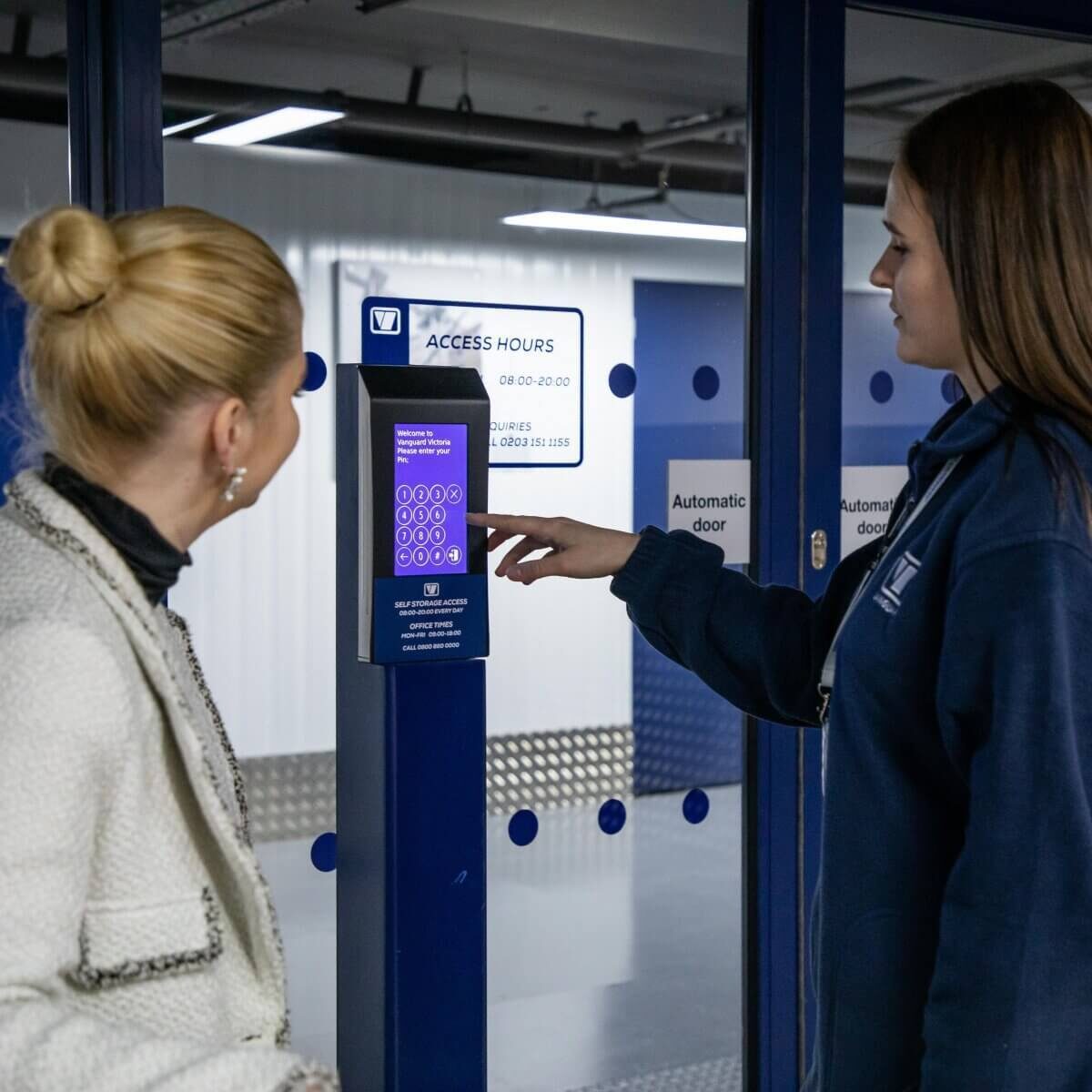A photo of a Vanguard employee showing a customer the security measures at one of Vanguard's self storage branches.