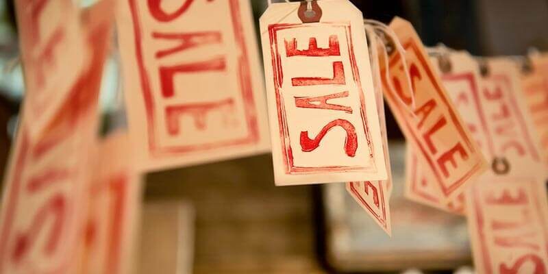 A photo showing many sale tags hanging on a thread.