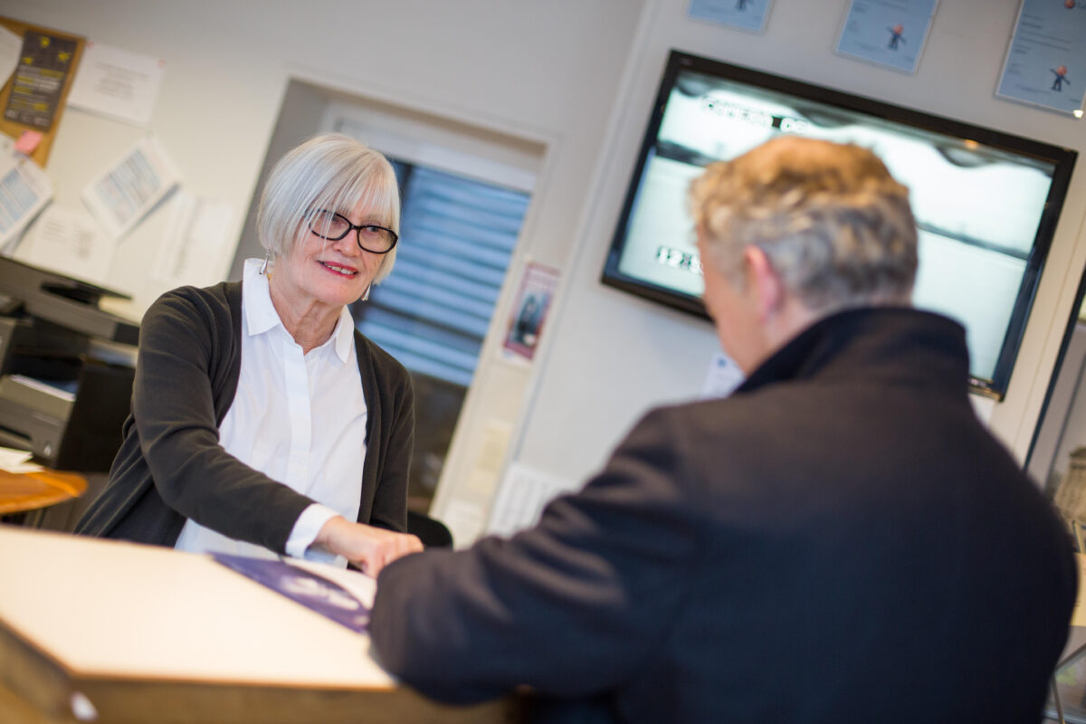 A photo of a Vanguard employee assisting a customer at the reception of one of Vanguard's Self Storage branches.