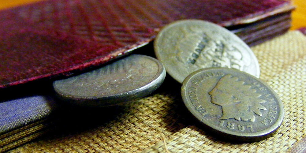 A photo showing three coins outside of a wallet.