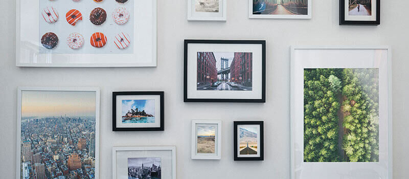 A photo showing a picture wall with various frames and photos.