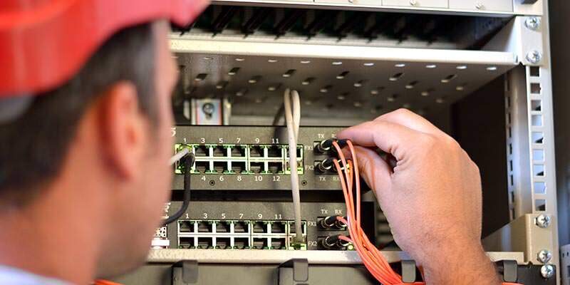 A photo showing a man connecting electricity cables.