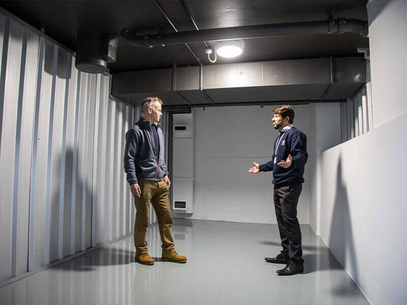 A photo showing a Vanguard employee showing a customer the inside of a Vanguard self-storage unit.