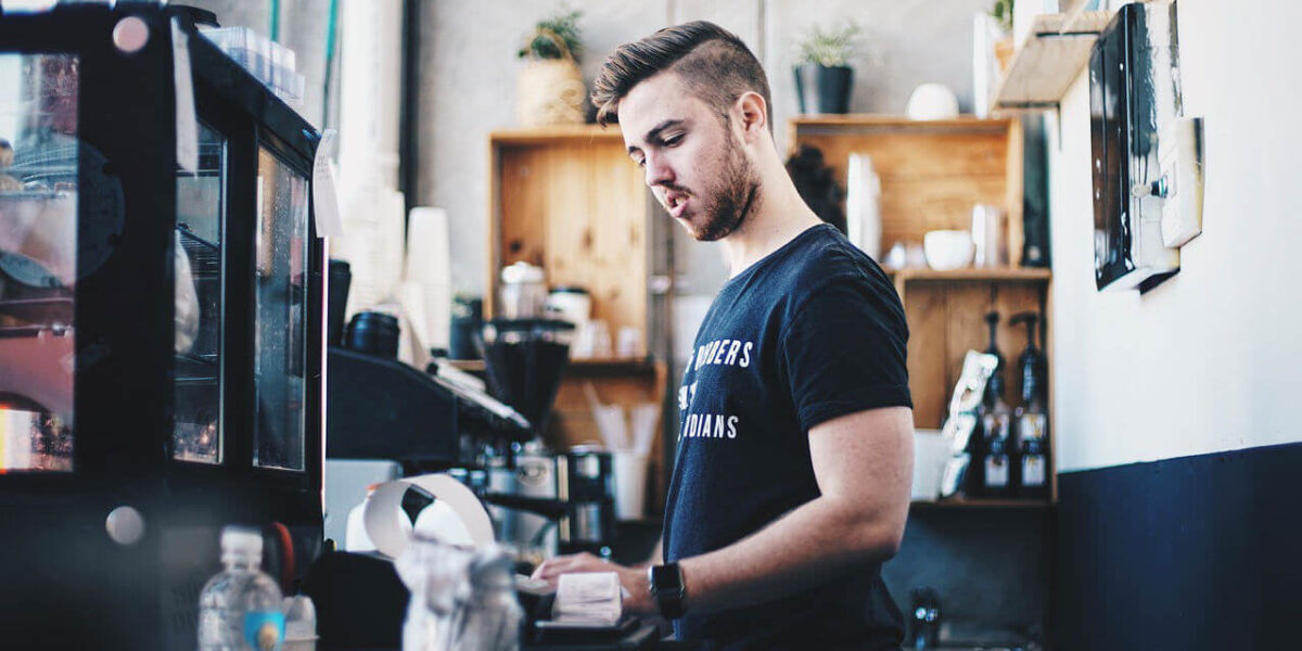 A photo of a barista making a coffee in a coffee shop.