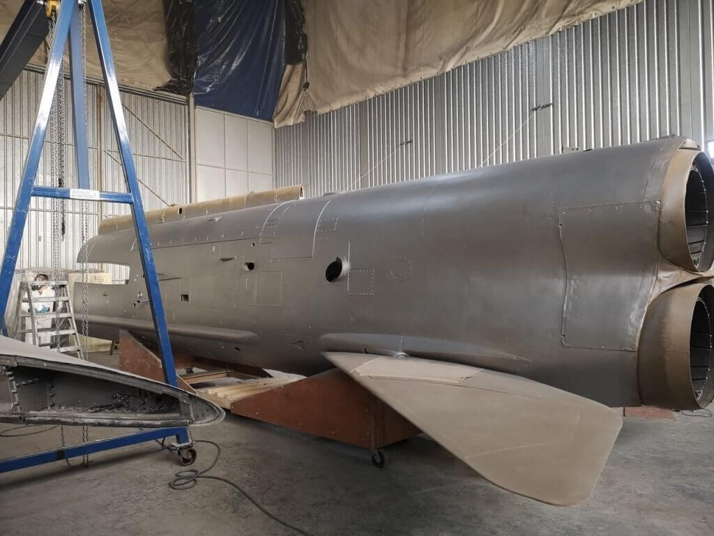 A photo showing the restoration process of the fighter jet hanging in the Vanguard Staples Corner branch.