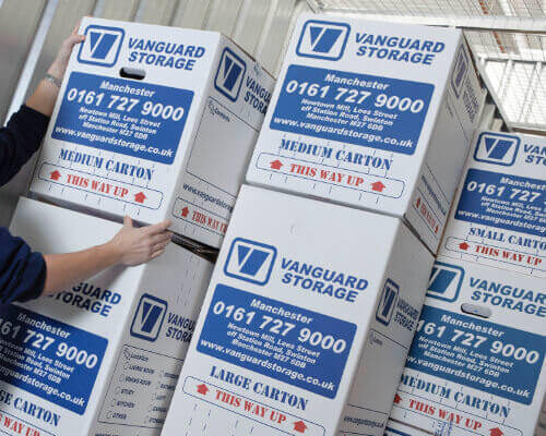 A photo showing a person stacking up Vanguard's cardboard boxes.