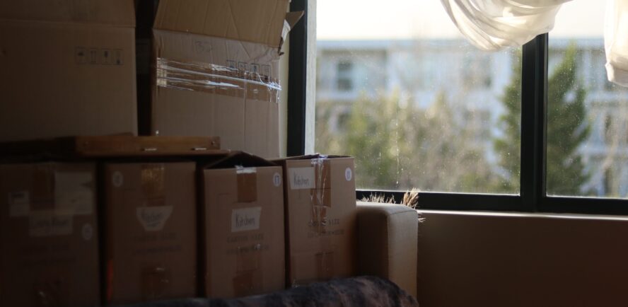 A photo showing labelled cardboard boxes in front of a window.