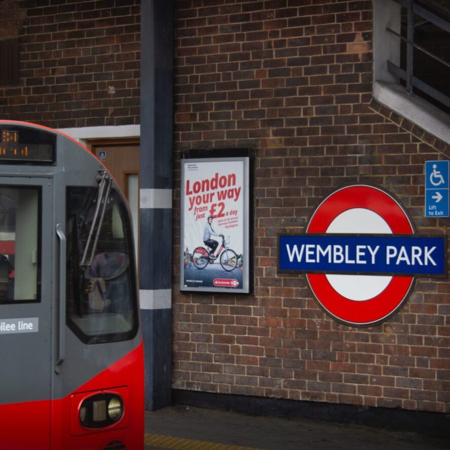 A photo showing a tube train pulling in to the Wembley Park underground station.