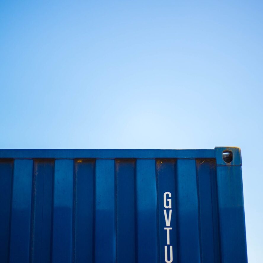 A photo showing the corner of a container storage against a clear blue sky.